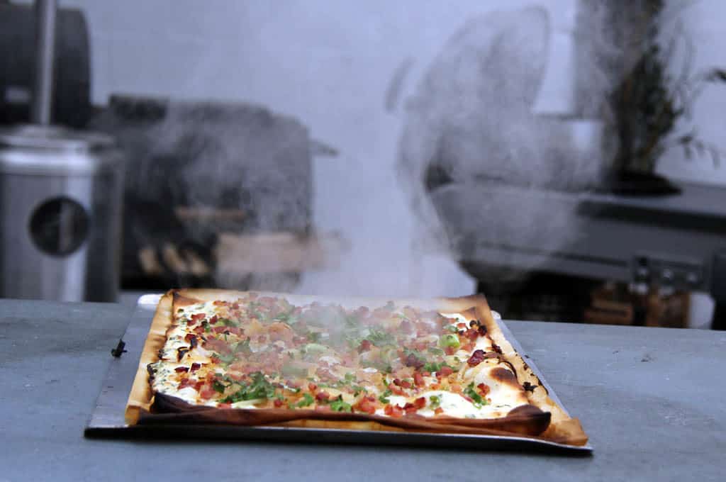 Prepare tarte flambée on the barbecue in a team at the barbecue course with 400 degree heat