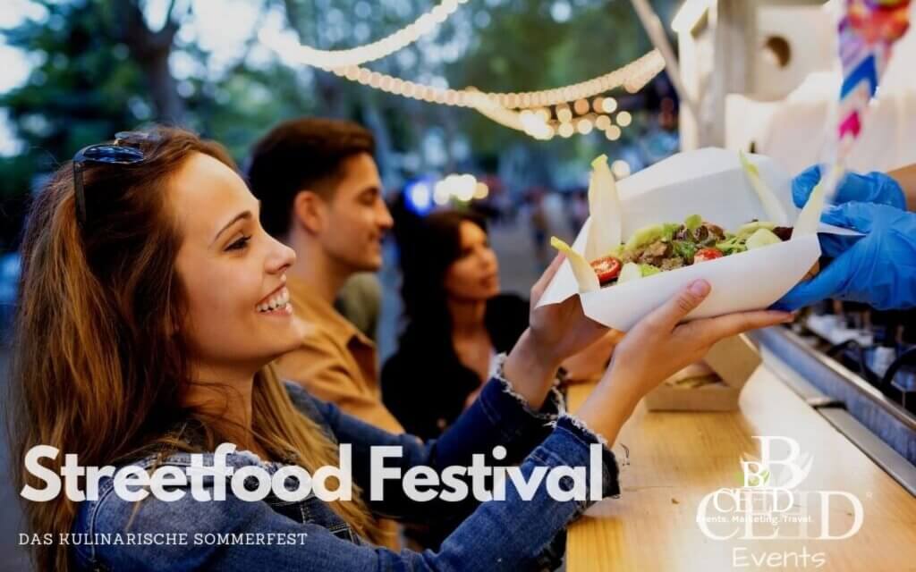 Ein Gast erhält eine Portion Essen an einer Streetfood-Station